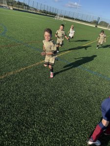 Young Nexgen players running across a full-size 3G pitch during a session