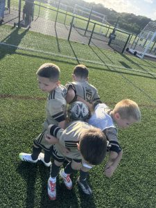 A small group of young Nexgen players gathered together with a ball