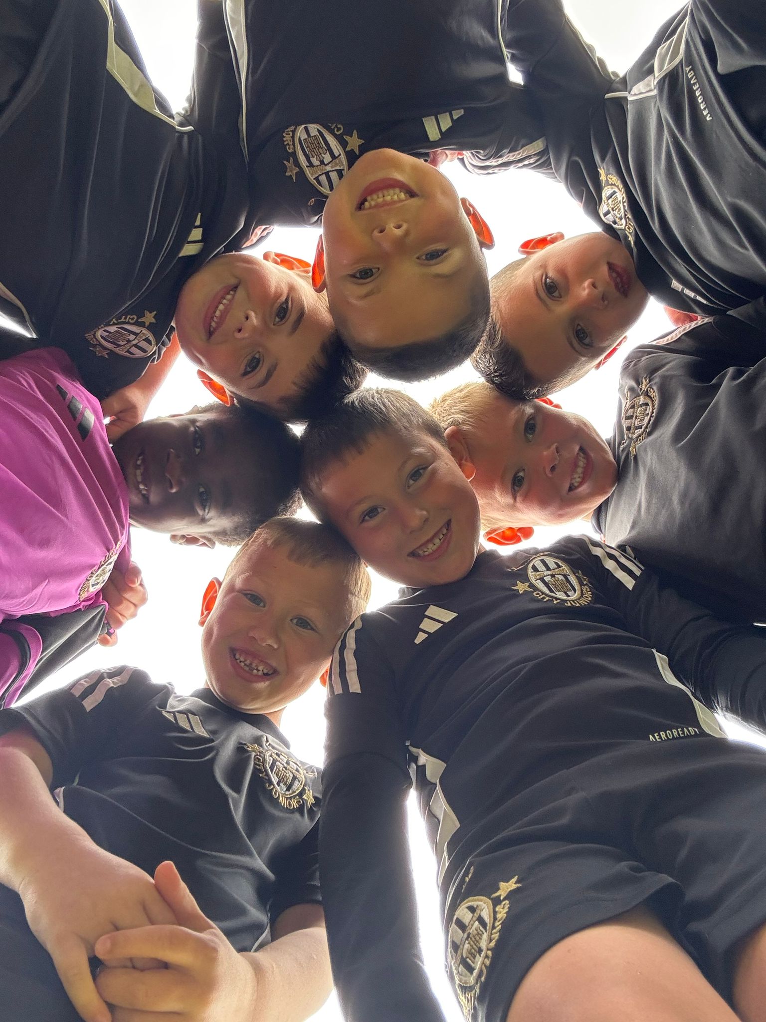 Nexgen players in black training tops huddled together looking down at the camera